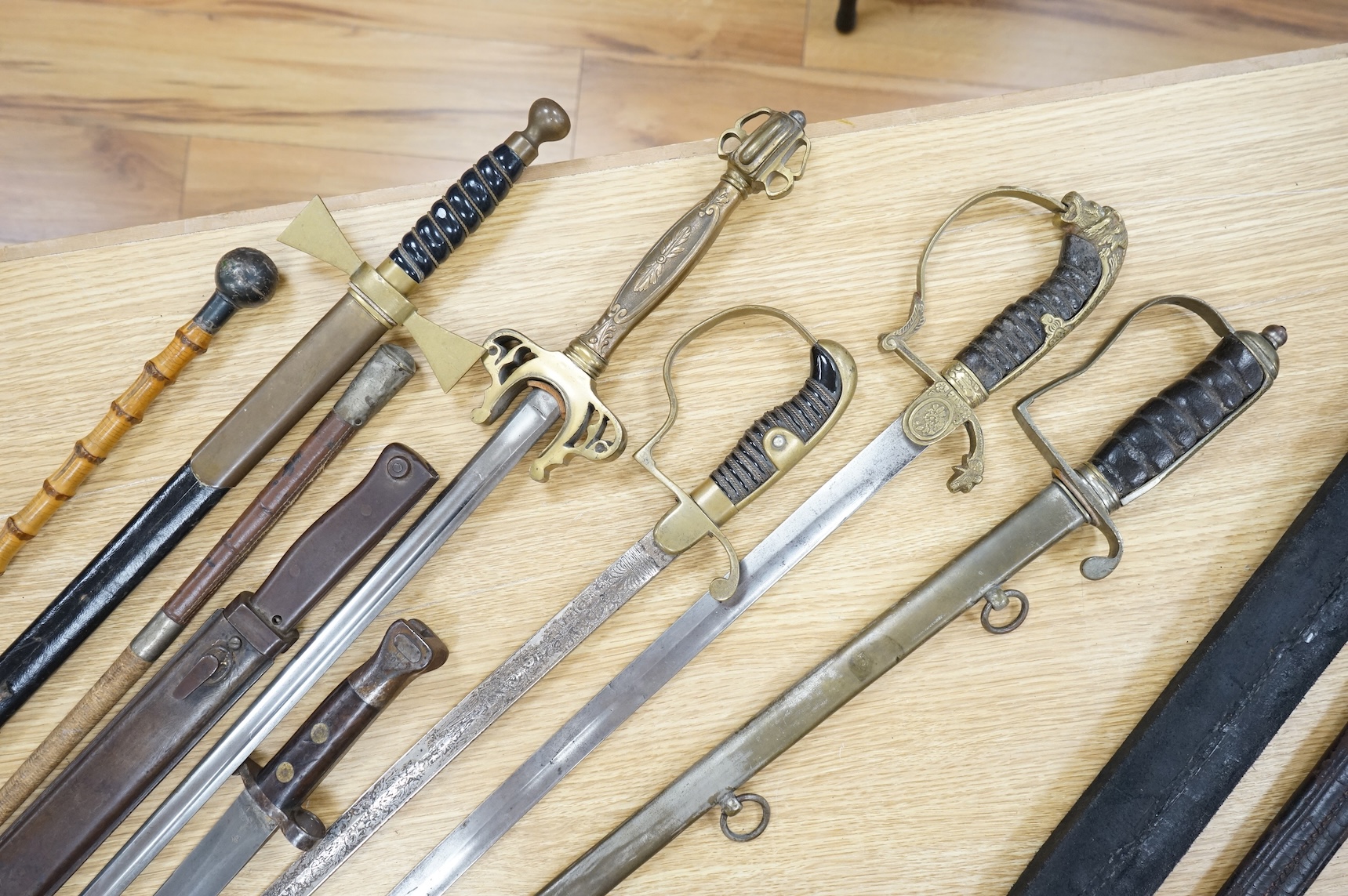 An Imperial German presentation infantry officer’s sword dated 1919/20, another similar with plain blade and brass stirrup hilt, another similar, plain in steel scabbard, a Wilkinson masonic sword probably circa 1950, a